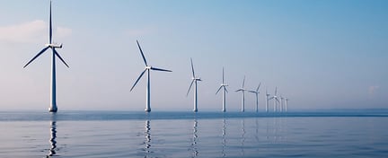 Row of wind turbines in sea, calm water